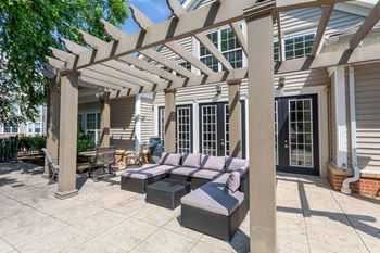 A patio with a couch and a pergola.